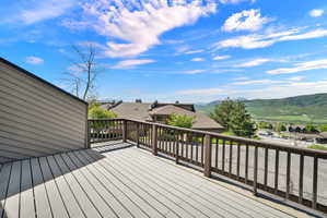 Expansive outdoor deck featuring wood-finish flooring and a wood railing