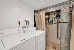 Dedicated utility area featuring white washer and dryer units, utility hookups, and a white ceiling with paneling