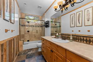 Bathroom featuring a wood-finish vanity with a single basin sink and a tiled countertop