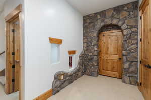 Stone archway entry featuring a solid wood door with dark hardware