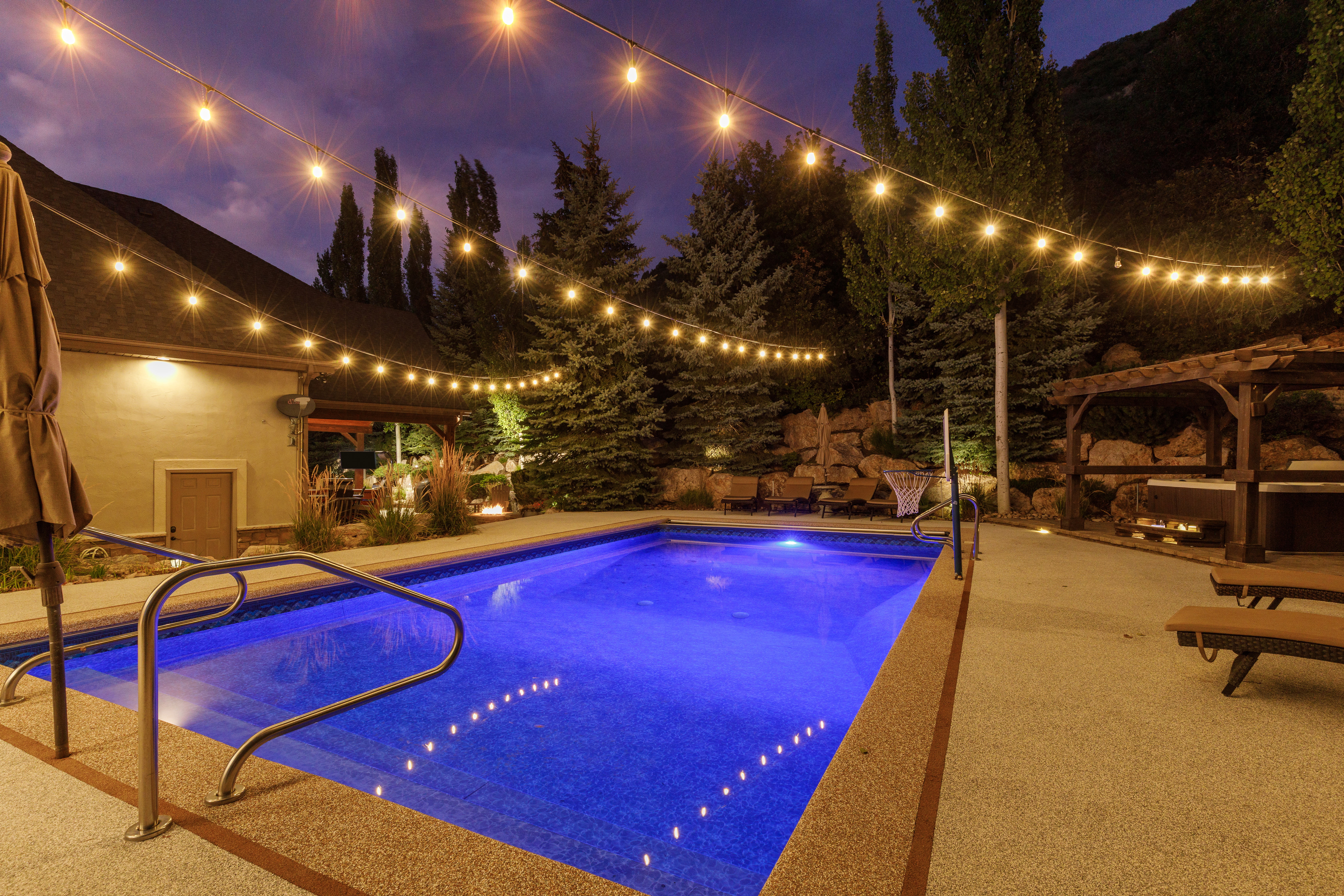 Resort-style pool area featuring a built-in swimming pool, a dedicated hot tub area with a pergola, and extensive hardscaping