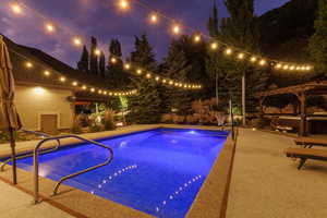 Resort-style pool area featuring a built-in swimming pool, a dedicated hot tub area with a pergola, and extensive hardscaping