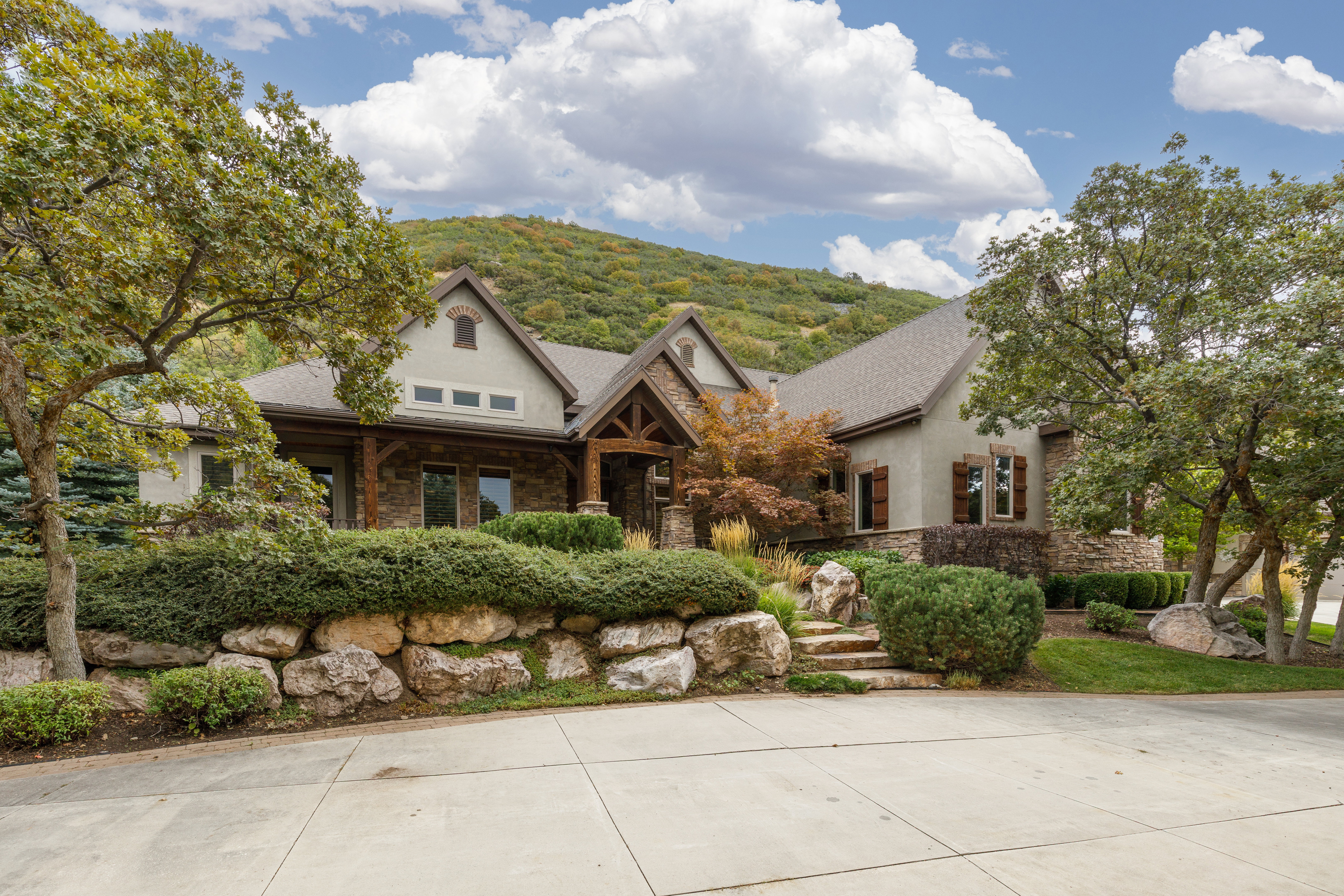 Stone and stucco exterior with multiple gables and dark wood accents