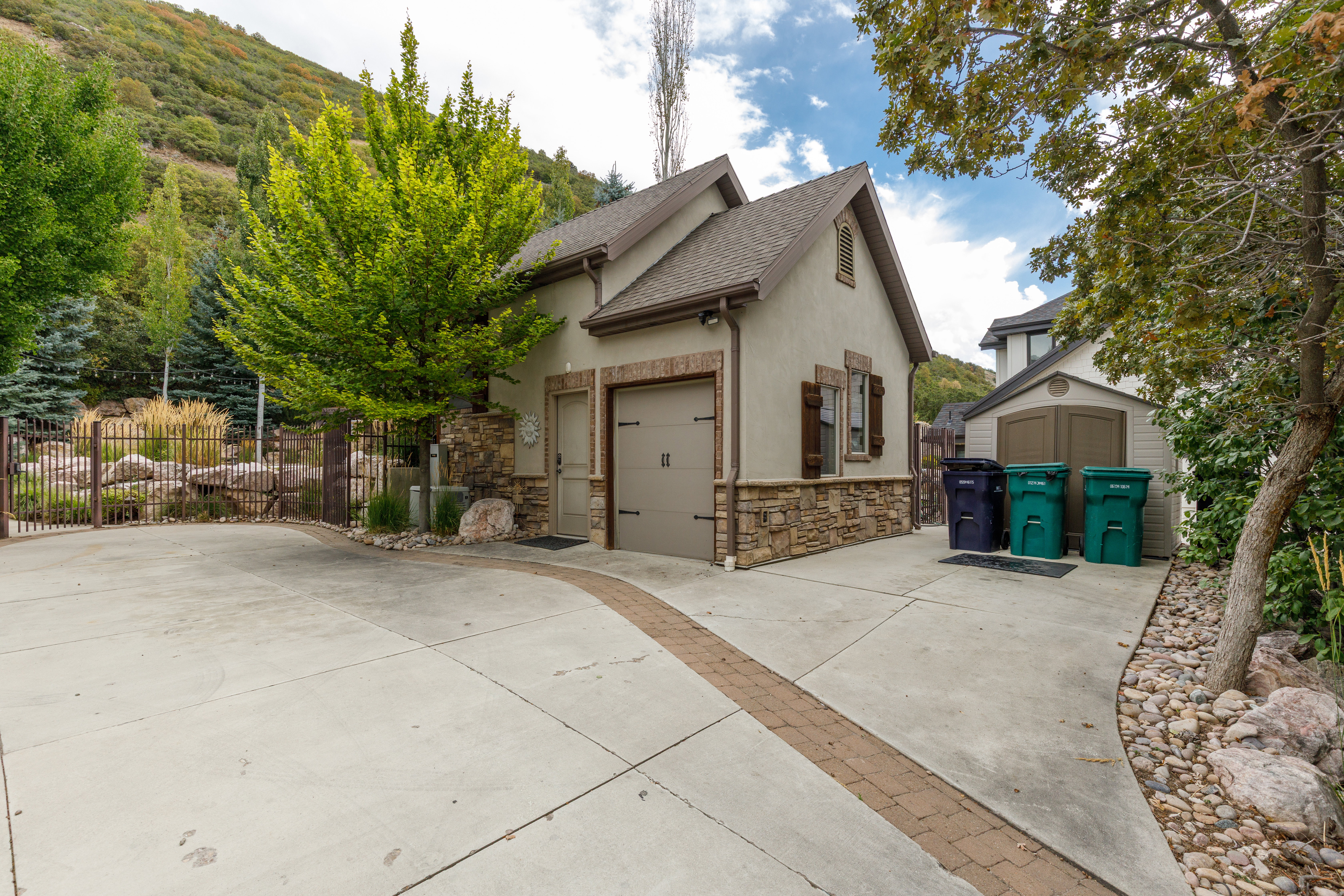 Attached garage with a neutral stucco exterior and stone veneer detailing