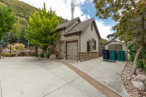 Attached garage with a neutral stucco exterior and stone veneer detailing