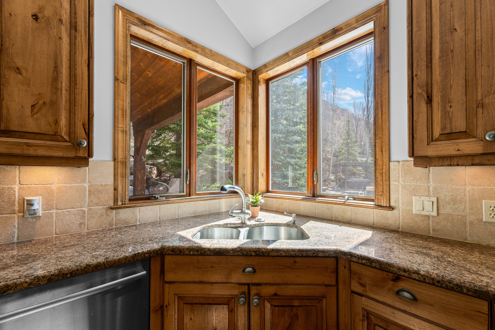 Corner kitchen sink with dual basins and stainless steel faucet