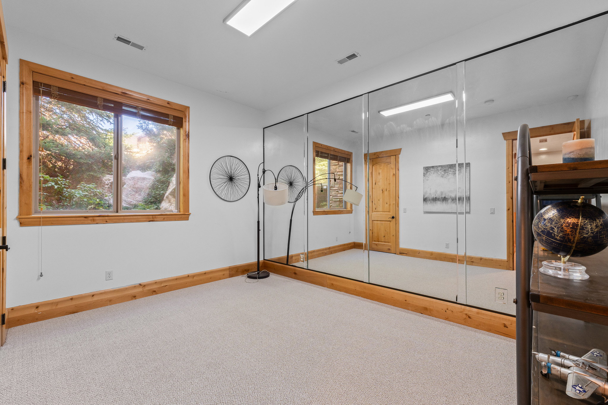 Wall-to-wall mirrored panels featuring a natural wood base