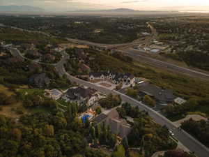 Aerial perspective showcasing a residential community with winding roads, established trees, and mountainous terrain
