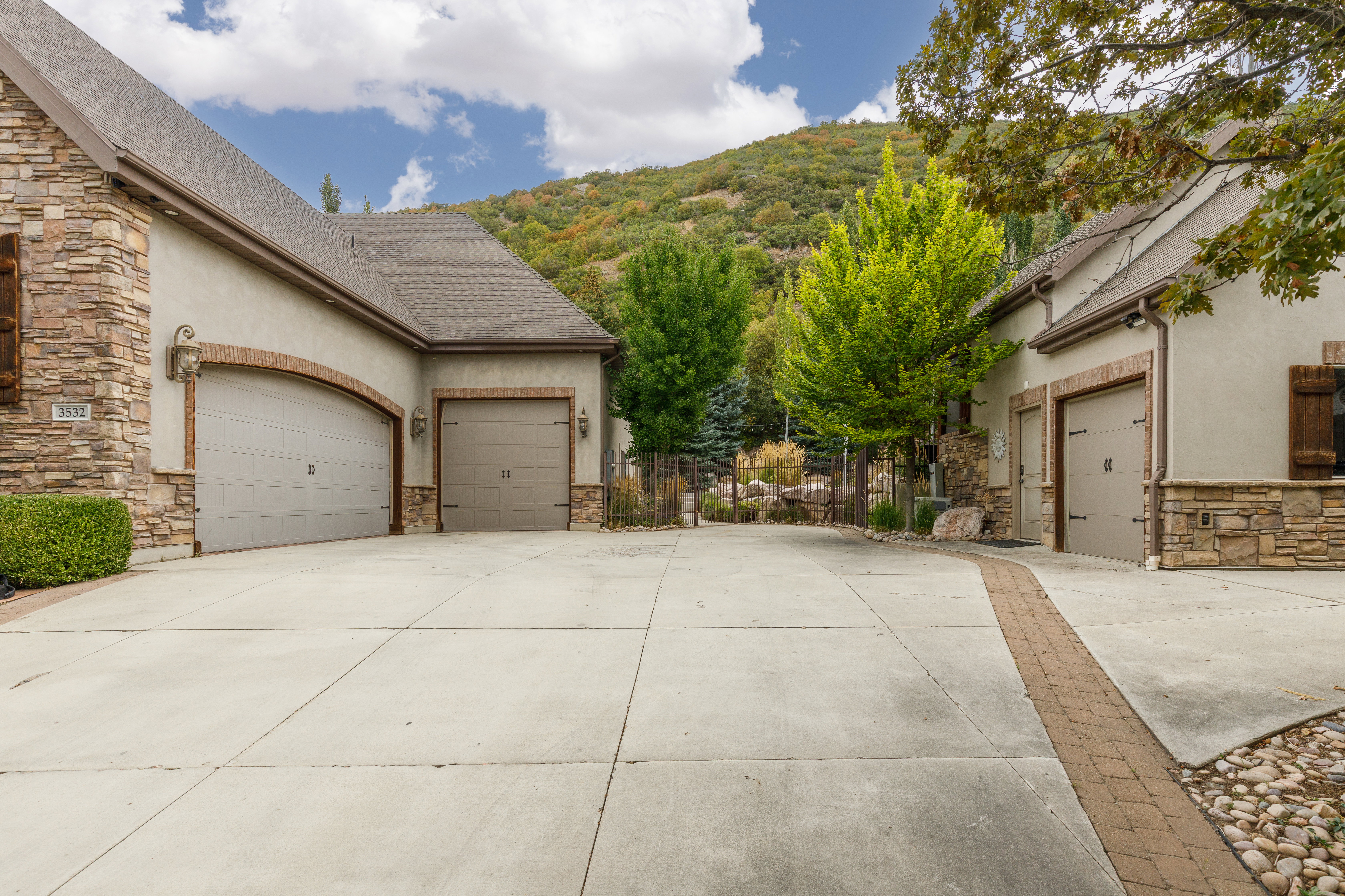 Stone veneer and stucco exterior with multiple garage doors