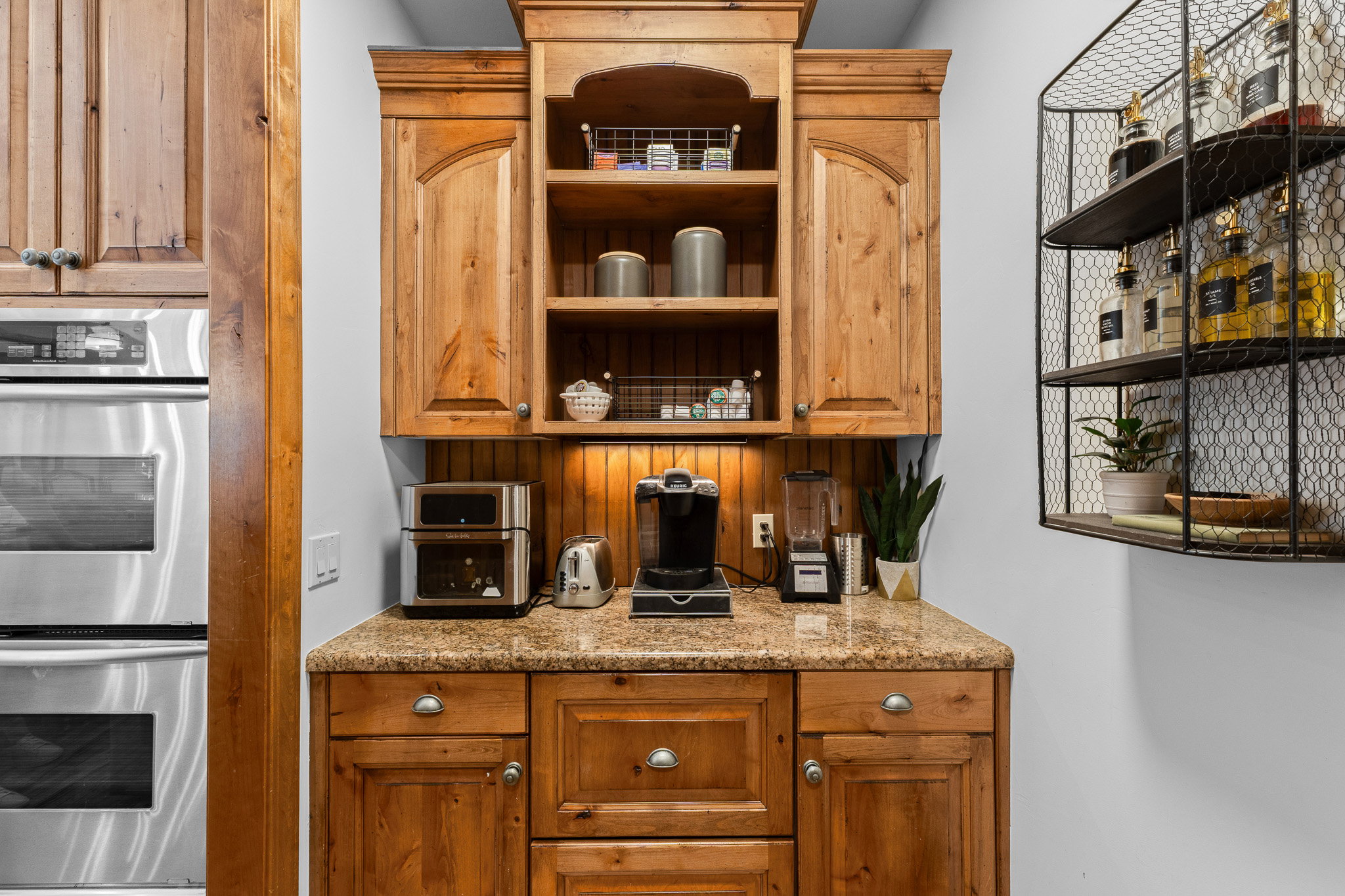 Custom-built cabinetry with a light wood finish and crown molding, complemented by a speckled countertop