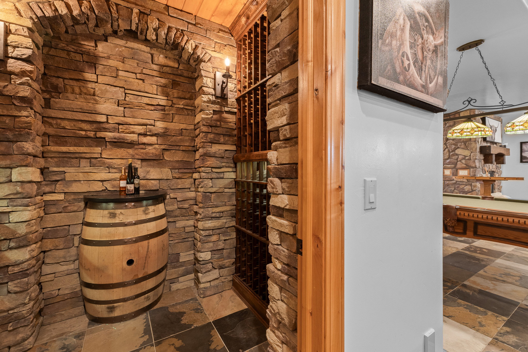 Stone-clad wine cellar featuring a wood rack system and overhead wood ceiling