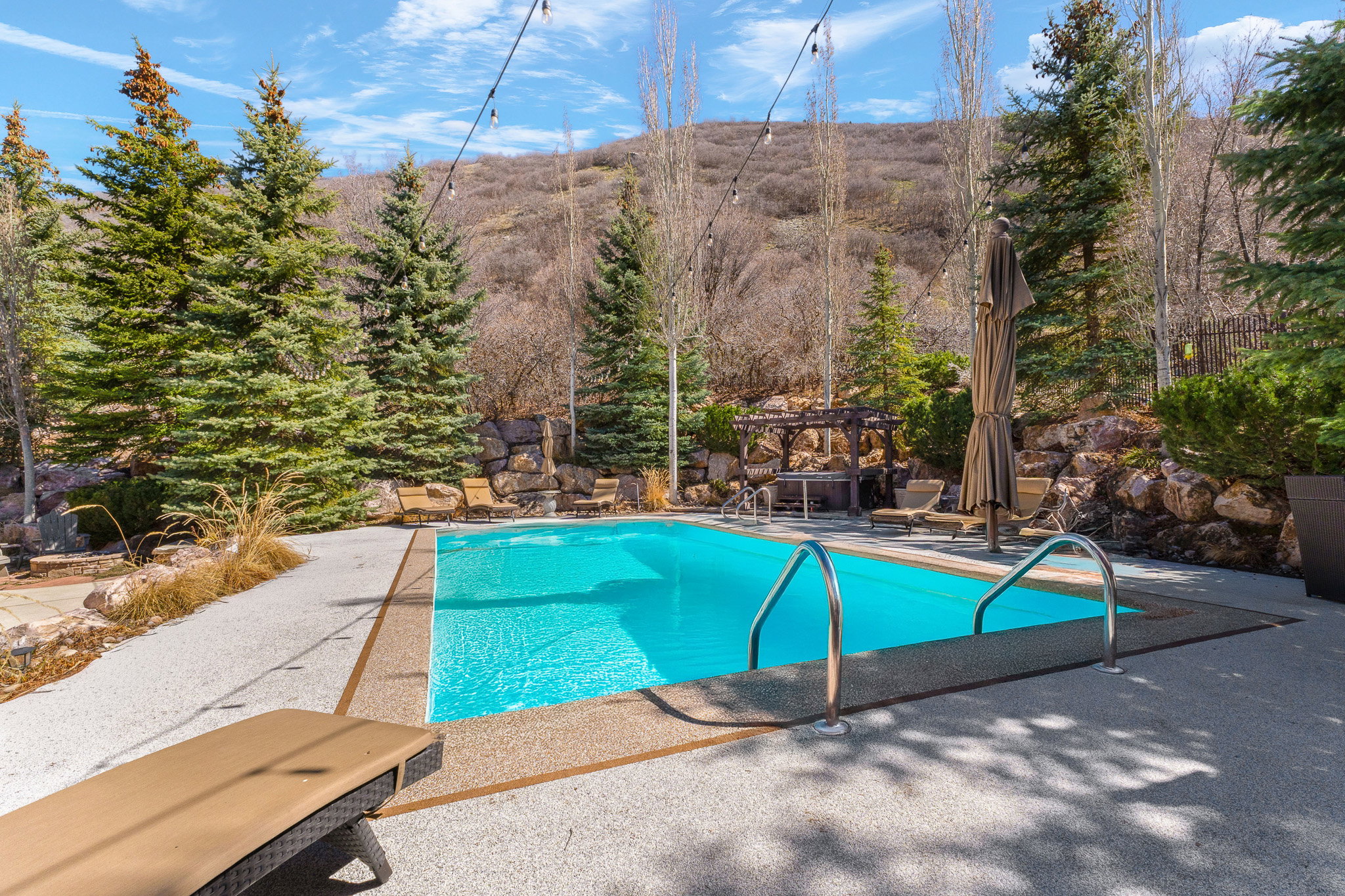 Outdoor swimming pool with concrete patio and stone retaining walls