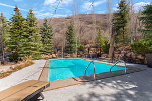 Outdoor swimming pool with concrete patio and stone retaining walls