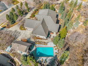 Expansive property featuring a multi-level main residence, a detached auxiliary building, and a rectangular swimming pool