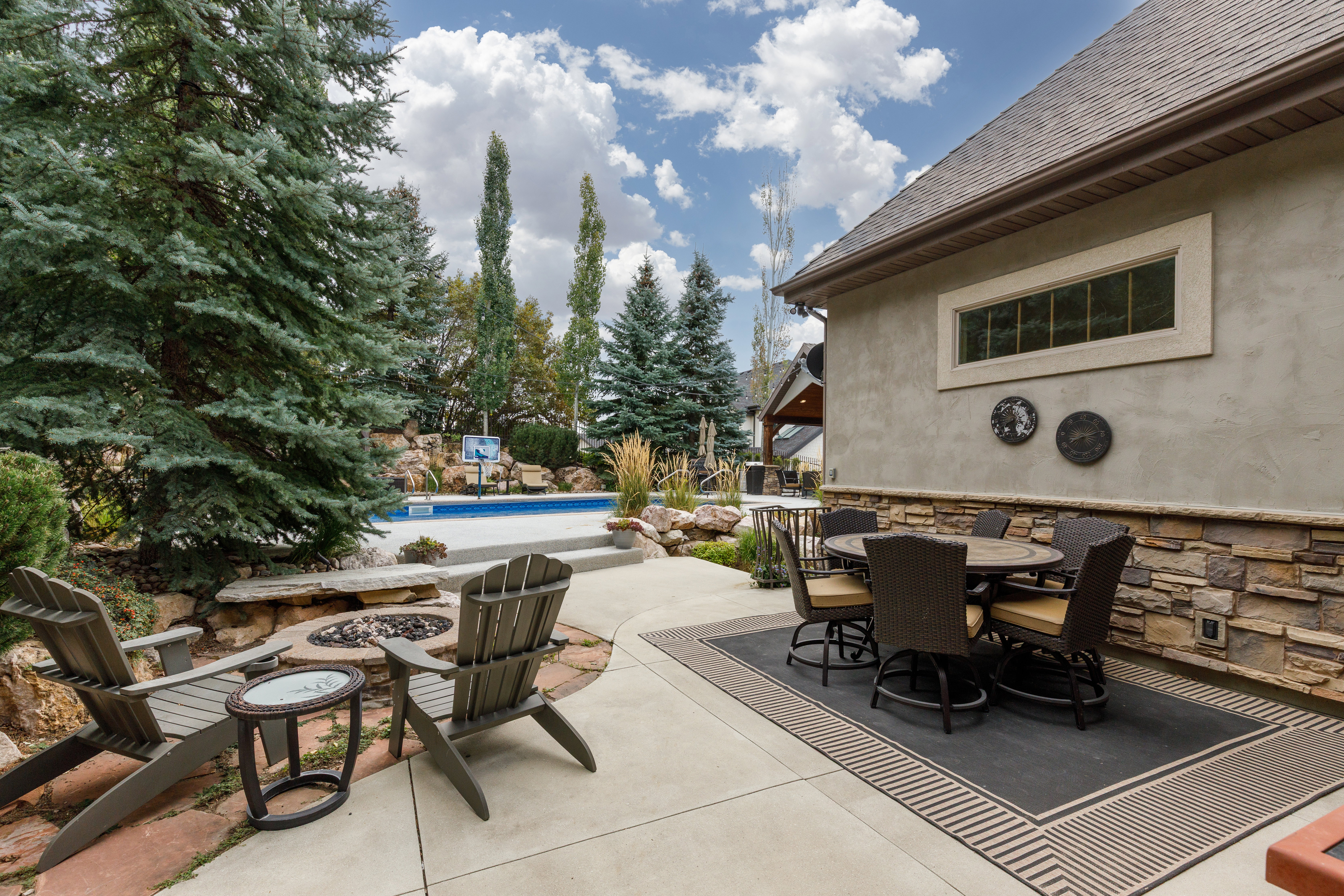 Stucco exterior featuring stacked stone accents and a concrete patio