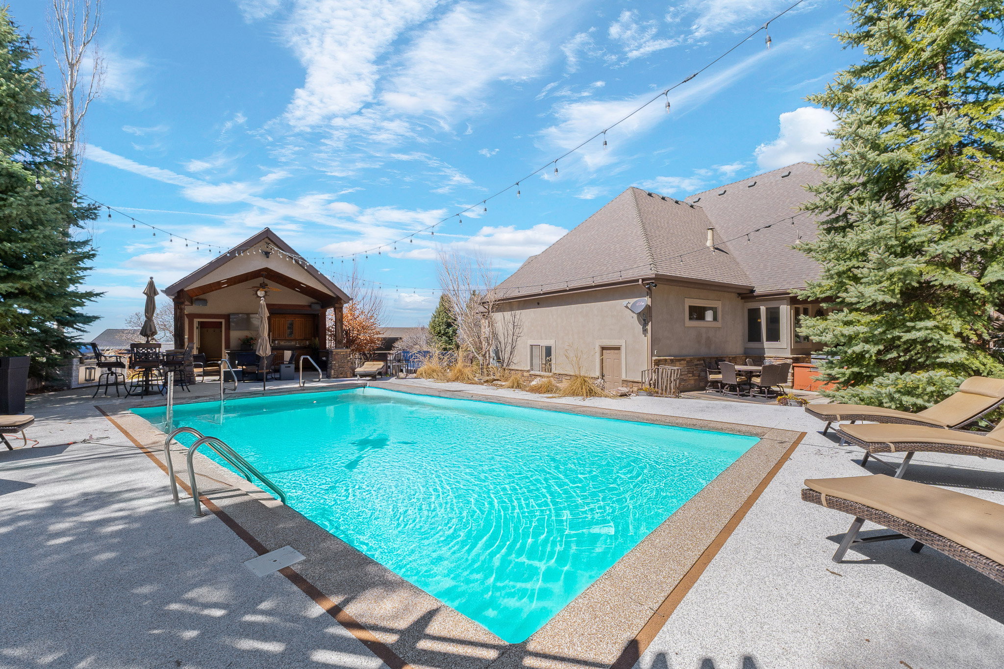 Outdoor swimming pool featuring a stone coping and a concrete surround