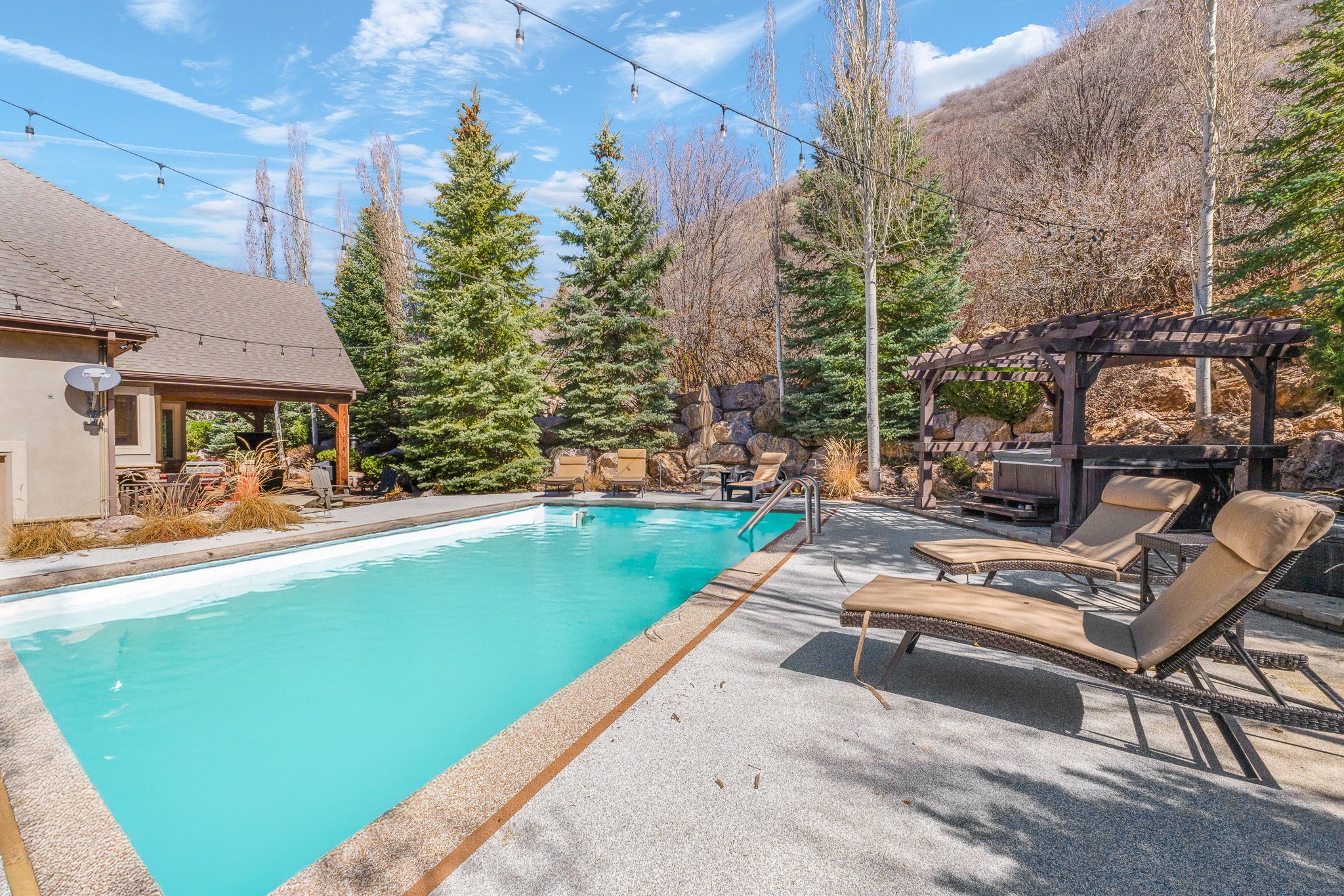 Outdoor swimming pool with integrated steps, surrounded by a textured concrete deck