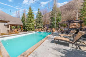 Outdoor swimming pool with integrated steps, surrounded by a textured concrete deck