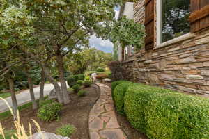 Stone veneer exterior with wood shutters, complemented by a flagstone pathway