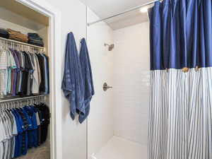 Shower enclosure with white subway tile surround, brushed nickel fixtures, and recessed ceiling lighting