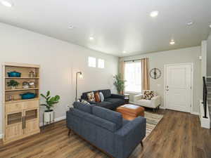 Spacious living area featuring wood-finish flooring, recessed lighting, and a neutral color palette