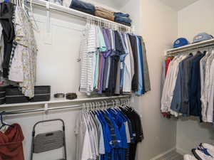 Organized closet system featuring multiple hanging rods, integrated shelving, and clean white walls