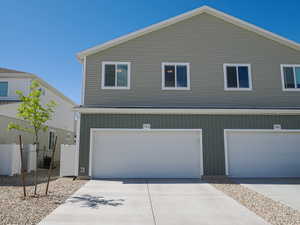 Modern multi-level townhome exterior featuring light green siding and white trim