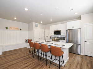 Modern kitchen with an island featuring a white countertop and seating at least 4