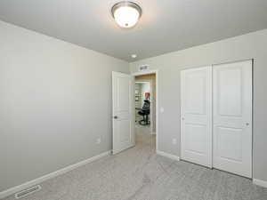 Neutral-toned room with light gray walls, textured carpeting, and white trim