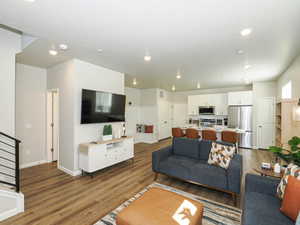 Open-concept living space featuring wood-finish flooring, recessed lighting, and a modern kitchen