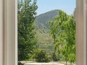 Window framing lush greenery and distant mountains