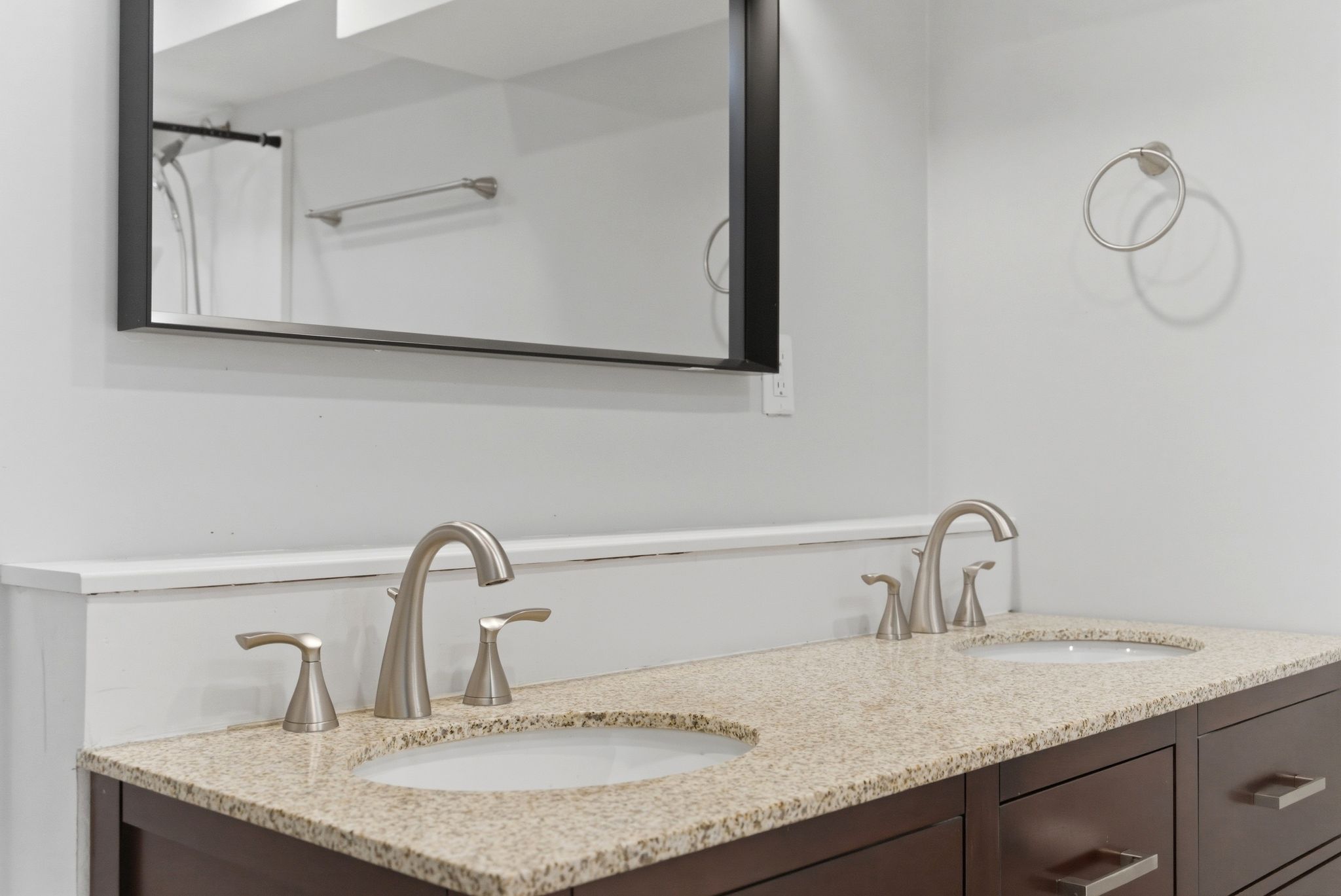 Dual vanity featuring granite countertops with undermount sinks and brushed nickel fixtures