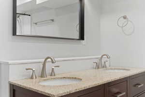 Dual vanity featuring granite countertops with undermount sinks and brushed nickel fixtures