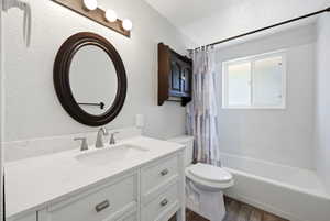 Bathroom featuring a white vanity with an undermount sink, brushed nickel faucet, and a large oval mirror