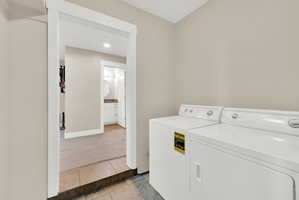 Dedicated laundry area featuring white appliances and tiled flooring