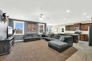 Open-concept living area featuring a ceiling fan, recessed lighting, and carpet flooring
