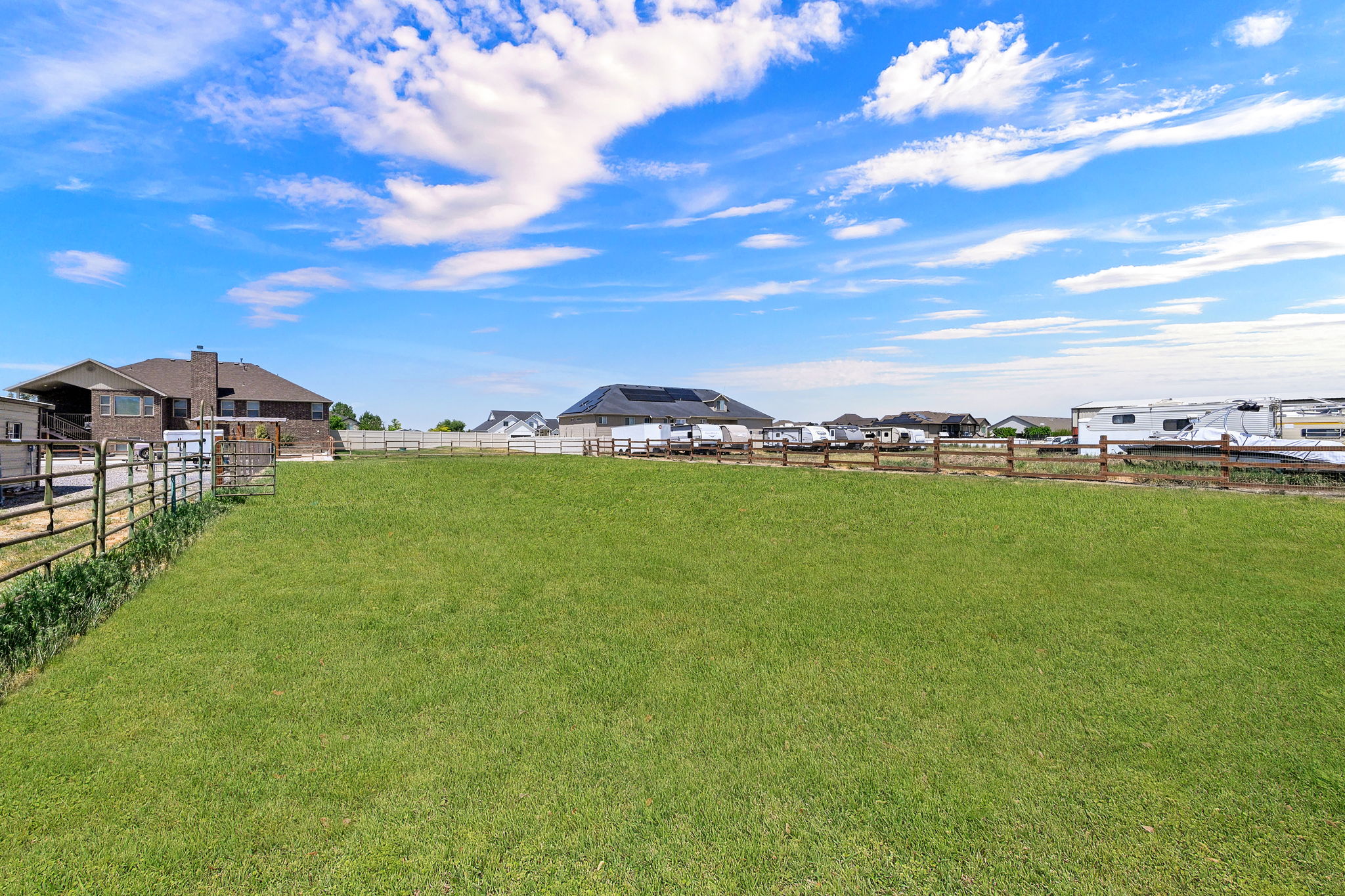 Expansive green lawn with a wooden perimeter fence, offering a significant outdoor area