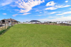 Expansive green lawn with a wooden perimeter fence, offering a significant outdoor area