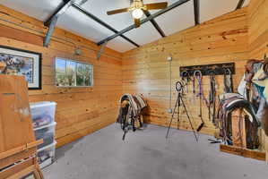 Room with plank wood-finish walls, a window, and a ceiling fan