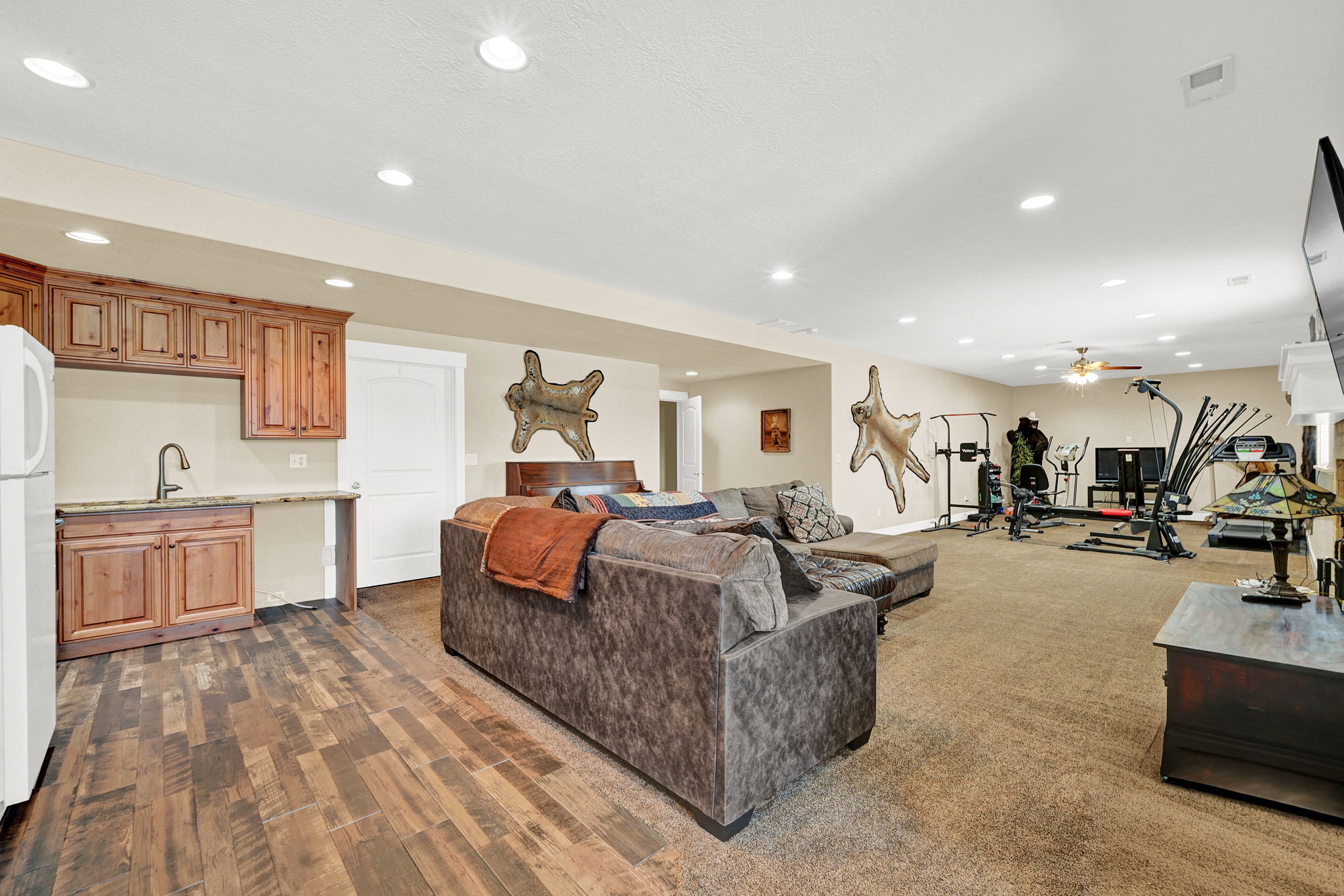 Spacious lower level featuring a wet bar with wood cabinetry and a undermount sink