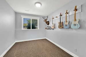 Carpeted room with light grey walls, white trim, and a window