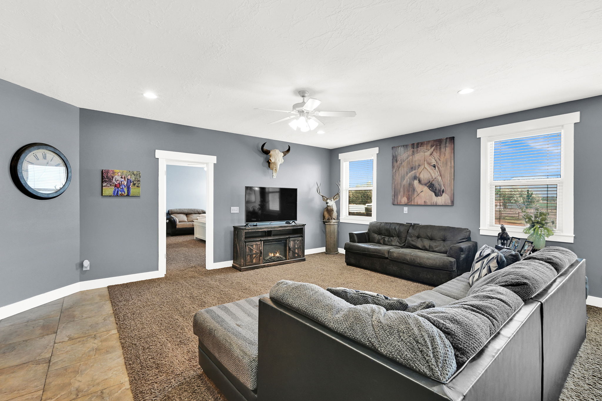 Carpeted living area featuring recessed lighting, a ceiling fan, and multiple windows