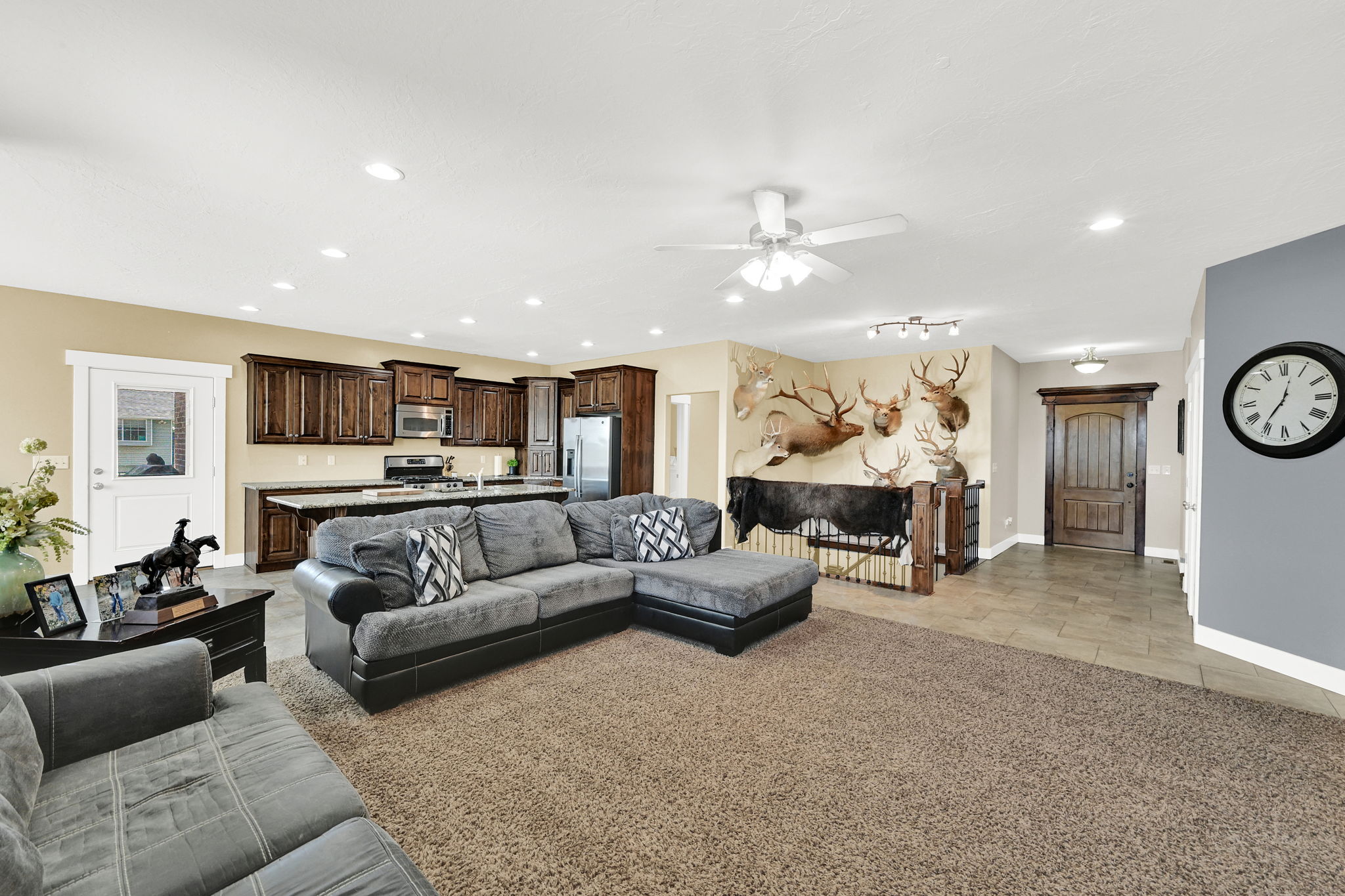 Open-concept main living area featuring wood-finish cabinetry, stainless steel appliances, and a central island with countertop seating
