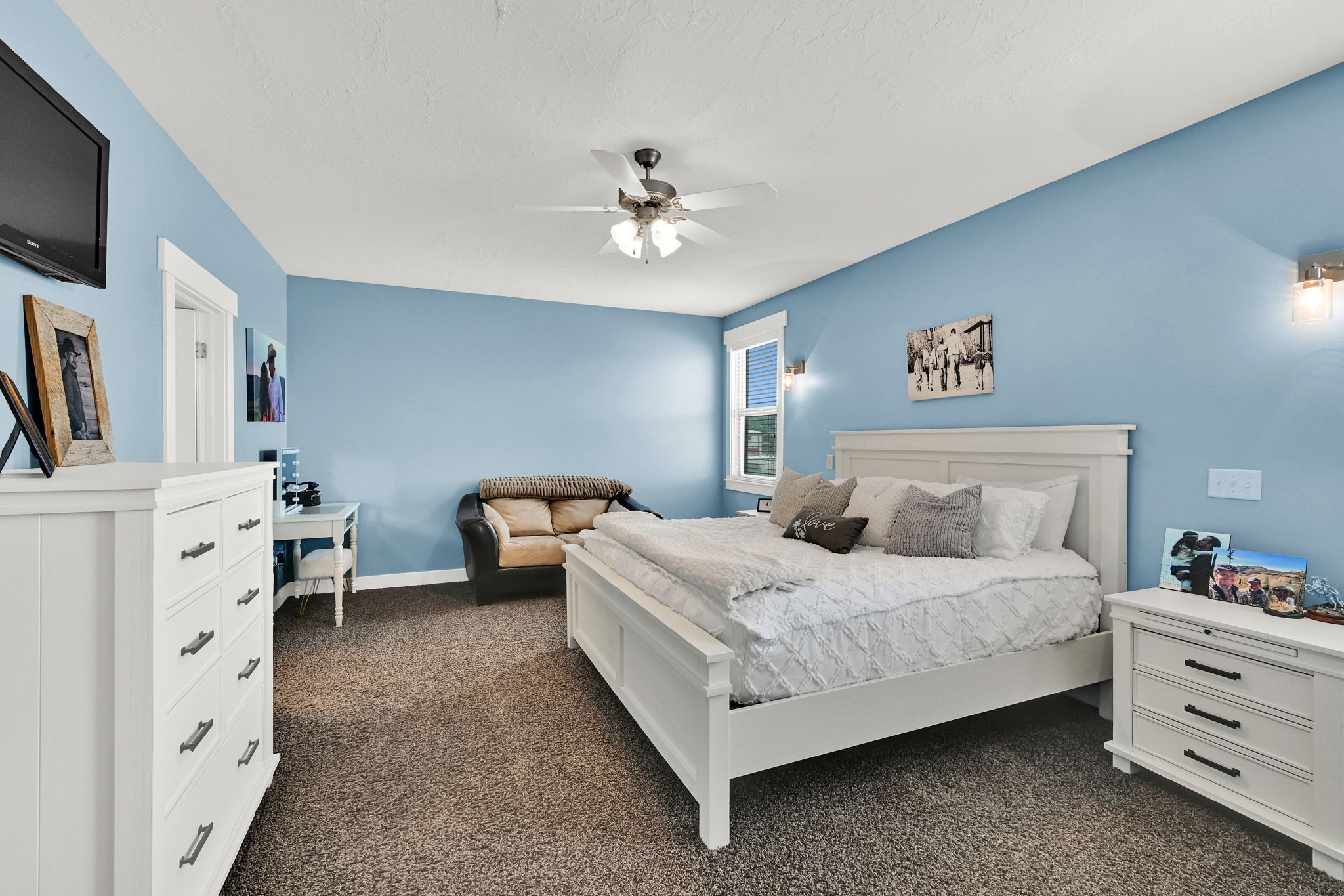 Carpeted room with a ceiling fan, light blue walls, and white trim