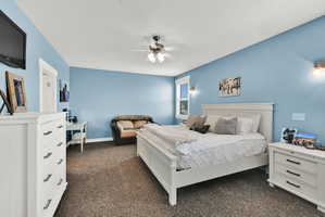 Carpeted room with a ceiling fan, light blue walls, and white trim