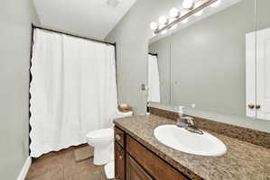Bathroom featuring a single vanity with a laminate countertop, an oval undermount sink, and a large wall mirror with a six-bulb vanity light fixture