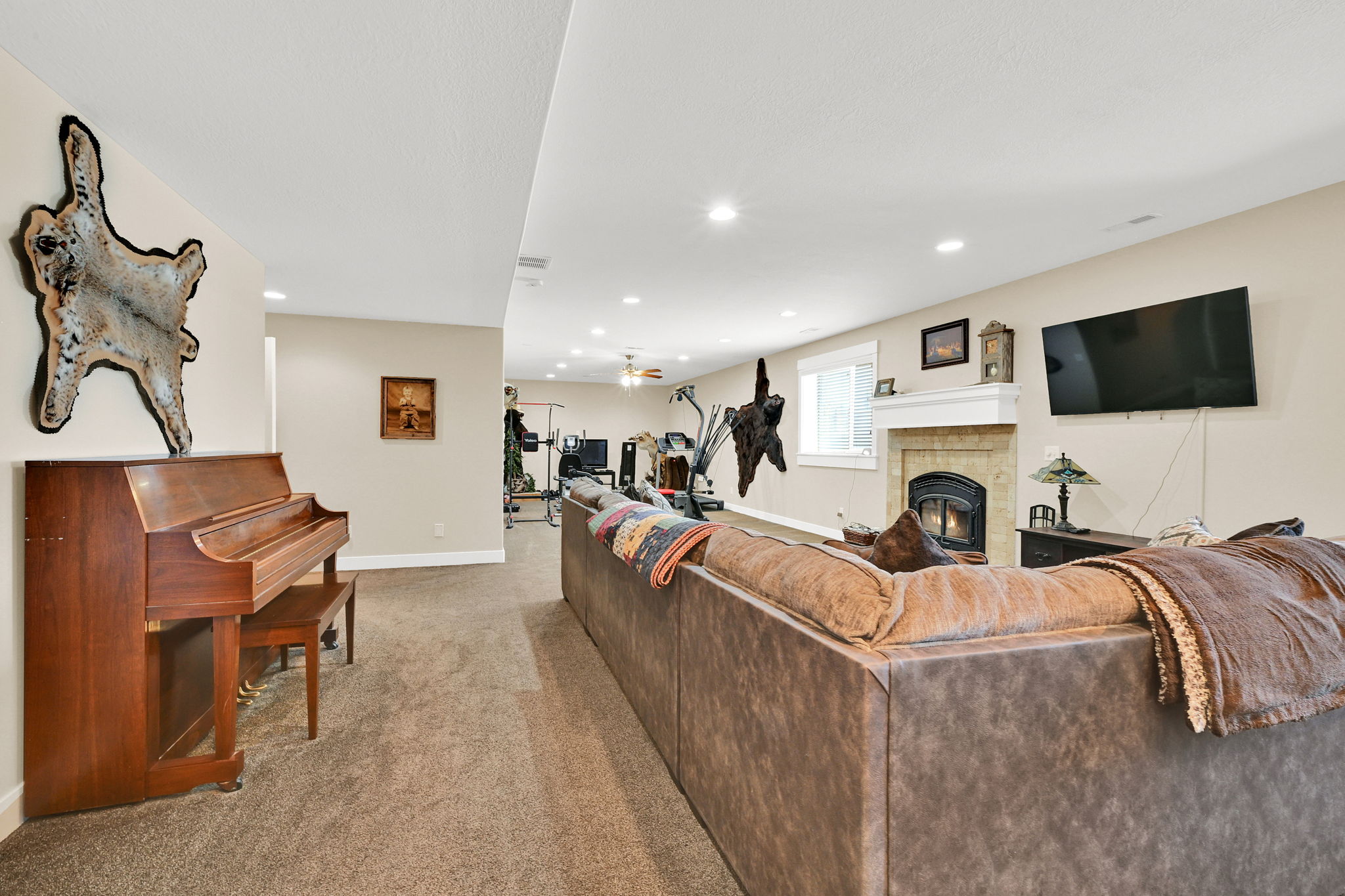 Spacious lower-level entertainment area featuring recessed lighting, neutral wall tones, and plush carpeting