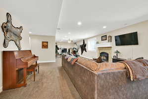 Spacious lower-level entertainment area featuring recessed lighting, neutral wall tones, and plush carpeting