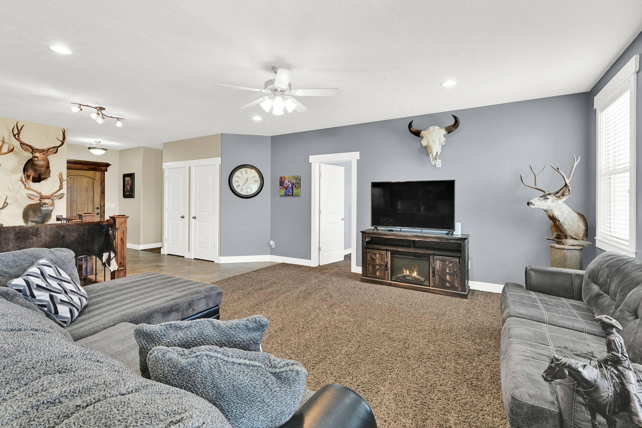 Spacious living area featuring neutral carpeting and light gray walls