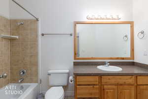 Bathroom featuring a single vanity with wood cabinetry, a built-in sink, and a speckled countertop